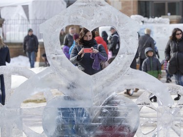 Jodi Leaderhouse takes a photo of people at an ice sculpture at Frosted Gardens on the Bessborough Hotel grounds, February 6, 2016.