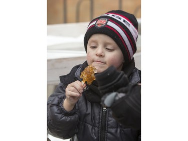 Four-year-old Ryder Weist enjoys some maple syrup taffy at Frosted Gardens on the Bessborough Hotel grounds, February 6, 2016.