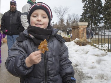 Four-year-old Ryder Weist poses for a photograph with his maple syrup taffy at Frosted Gardens on the Bessborough Hotel grounds, February 6, 2016.