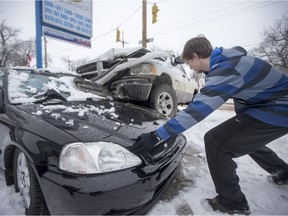 Ryan Stettner assesses the damage to the front end of his car as Saskatoon Police investigate at the scene of a vehicle collision at the corner of 33rd Street West and Avenue D North after a truck hit a parked car on Monday, Feb. 15, 2016.