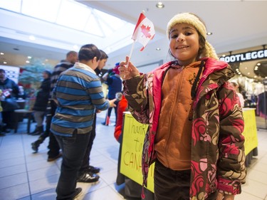 A young Syrian refugee poses for a photograph before she and other newly arrived Syrian refugees handed out roses at Lawson Heights Mall in Saskatoon to thank Canadians, February 21, 2016.