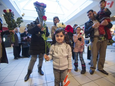 A young syrian refugee poses for a photograph before she and other newly arrived Syrian refugees handed out roses at Lawson Heights Mall in Saskatoon to thank Canadians, February 21, 2016.