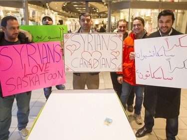 Mohammed Al-Helal (R) stands with friends and signs before he and other newly arrived Syrian refugees handed out roses at Lawson Heights Mall in Saskatoon to thank Canadians, February 21, 2016.