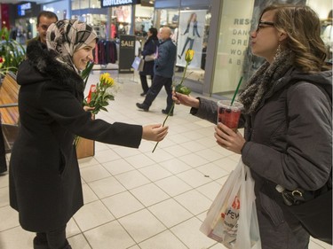 Newly arrived Syrian refugees hand out roses at Lawson Heights Mall in Saskatoon to thank Canadians on February 21, 2016.