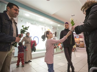 Newly arrived Syrian refugees hand out roses at Lawson Heights Mall in Saskatoon to thank Canadians, February 21, 2016.