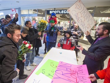 Syrian refugees distribute flowers and signs before they handed out roses at Lawson Heights Mall in Saskatoon to thank Canadians, February 21, 2016.