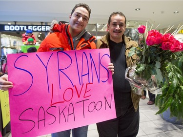Syrian refugees pose for a photograph before they and other newly arrived Syrian refugees handed out roses at Lawson Heights Mall in Saskatoon to thank Canadians, February 21, 2016.