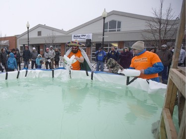 Polar Dippers add ice to a small pool prior to the Polar Dip to fight human trafficking at the Farmers market on Saturday, February 27th, 2016.
