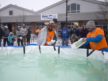 Polar Dippers add ice to a small pool prior to the Polar Dip to fight human trafficking at the Farmers market on Saturday, February 27th, 2016.