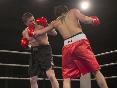 Matt Dumais, right, lands a punch on Kelly Paige during the At Last: Championship boxing at Prairieland Park on Saturday, February 27th, 2016.
