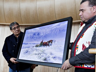 The unveiling of the Michael Lonechild (L) painting with help from Thunderchild First Nation chief Delbert Wapas at the grand opening celebrations for Gordon Oakes Red Bear Student Centre at the University of Saskatchewan, February 3, 2016.