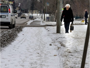 Staying clear of ice covered sidewalks means walking on the crunchy snow next to it which seems a lot easier for this woman on Pinehouse Drive, February 9, 2016.