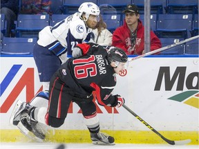 Saskatoon Blades forward Lukus MacKenzie runs over Moose Jaw Warriors forward Blake Bargar in second period WHL action on Sunday, January 3rd, 2016.