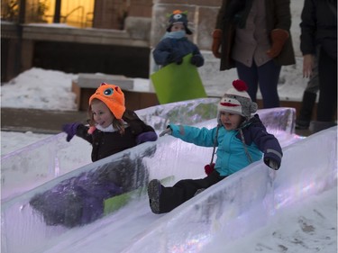 Kennedy Voss, left, and Aubree Moberly-Laprise slide on an ice slide during the Frosted Gardens ice park and sculpture display at the Bessborough Hotel, which opened to the public, Monday, February 01, 2016.