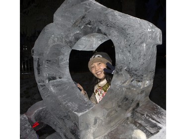Xiao Ping Le poses in one of a number of ice sculptures during the Frosted Gardens ice park and sculpture display at the Bessborough Hotel, February 1, 2016.