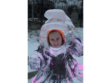 Kennedy Voss poses inside an ice sculpture during the Frosted Gardens ice park and sculpture display at the Bessborough Hotel, February 1, 2016.