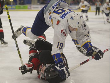 Ryan Graham of the Saskatoon Blades crushes Joseph Carvalho of the Prince George Cougars during Western Hockey League action at SaskTel Centre in Saskatoon, February 2, 2016.