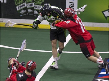 Chris Corbeil of the Saskatchewan Rush is taken off the ball by Curtis Manning of the Calgary Roughnecks and teammate Mike Carnegie.