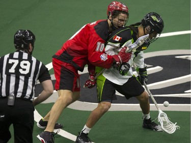 Curtis Manning of the Calgary Roughnecks, left, and Jeremy Thompson of the Saskatchewan Rush fight for control of the ball during National Lacrosse League action in Saskatoon at SaskTel Centre on Friday.