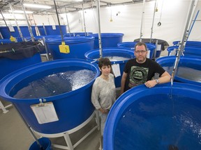 Scientists Maud Ferrari and Doug Chivers pose beside fish holding tanks in the RJF Smith Centre for Aquatic ecology at the U of S.