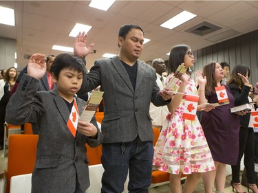 Seventy-Five people living in Saskatchewan were sworn in as Canadians in a citizenship ceremony at the Frances Morrison Library,  February 11, 2016. L-R: Abcde Briones, dad Jayson Briones, sister Julia Briones and Anna Lee Briones from the Philippines repeat the oath of citizenship.