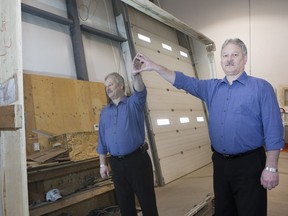 Darrell Drozd, owner of specialty glass business Total Service and Contracting, poses with mirror materials at the company's Millar Avenue location.