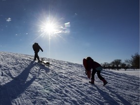 Aaron Doell (L) and his daughter enjoy the new snow and sunshine in Pierre Radisson Park, February 17, 2016.