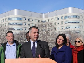 NDP leader Cam Broten, centre, promises more beds and longer hours at City Hospital during a news conference in front of the hospital.