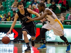 University of Saskatchewan Huskies guard  Evan Ostertag (2) tries to get past Brandon Bobcats guard Ilarion Bonhomme in Canada West men's basketball action  (DEREK MORTENSEN/STAR PHOENIX)