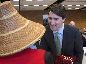 Prime Minister Justin Trudeau, right, presents Deanna George, aTsleil Waututh elder, with a gift during a meeting of the First Ministers, First Nations, Inuit, and Metis Leaders in Vancouver, B.C., Wednesday, March. 2, 2016. THE CANADIAN PRESS/Jonathan Hayward