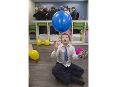 Ten-year-old Daniel Lepage plays with a balloon as Sask Party leader Brad Wall speaks to media at the Ability In Me (AIM) Centre, March 21, 2016.