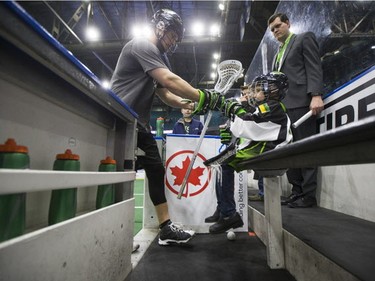 Nine-year-old Cohyn Wells gets a fist pump from Rush transition/defender Adrian Sorichetti on the bench after Wells signed a one-day contract with the Saskatchewan Rush, March 26, 2016. Wells is the Saskatchewan representative for the Children's Miracle Network's Champion Program.