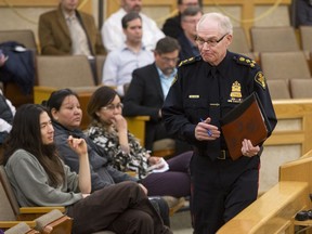 Saskatoon police chief Clive Weighill, right, leaves the podium after speaking to Saskatoon City Council as members of a group calling themselves the Saskatoon Coordinating Committee Against Police Violence look on during a meeting on March 21, 2016.