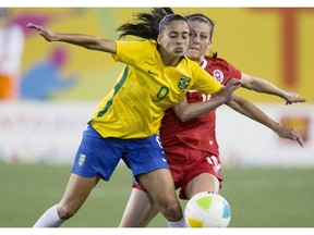 File Photo. Canada's Chelsea Stewart (16) and Brazil's Andressa Alves (9) battle for ball possession during 2015 Pan Am Games first half women's soccer action in Hamilton, Ontario, on Sunday, July 19, 2015. On Mar 8, 2016, Shelina Zadorsky and Janine Beckie scored second-half goals as Canada defeated Brazil 2-1 Monday in the final of Algarve Cup women's soccer tournament.