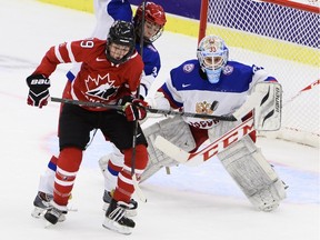 Canada's Emily Clark, left, vies with Russia's Svetlana Tkachyova in front of Russia's goalkeeper Maria Sorokina during the 2015 IIHF Ice Hockey Women's World Championship group A match between Canada and Russia at Malmo Isstadion in Malmo, southern Sweden, Sunday, March 29, 2015.