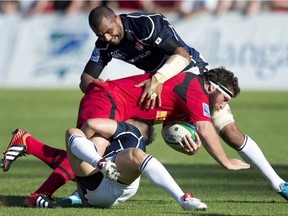 Team Canada's Hubert Buydens is tackled by Japan's Akihito Yamada, centre, and Michael Leitch during their international rugby match at Swangard Stadium in Burnaby, B.C., Saturday, June, 7, 2014.