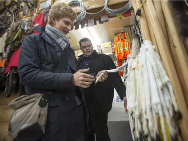 Jan Lisiecki, classical pianist (L) and Mark Turner, Executive Director of the Saskatoon Symphony Orchestra, look at some pelts at the Robertson Trading Co. in La Ronge during a Cameco sponsored tour of northern Saskatchewan on March 3, 2016.