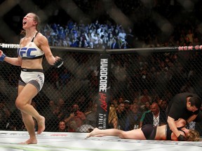 Miesha Tate, left, celebrates victory over Holly Holm in their UFC 196 women's bantamweight mixed martial arts match, Saturday, March 5, 2016, in Las Vegas.