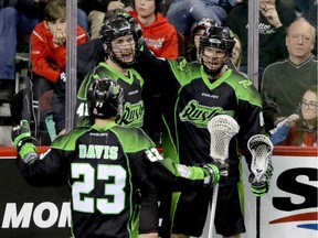 Saskatchewan Rush Jarrett Davis, Dan Taylor and Zack Greer celebrate their overtime win against the Calgary Roughnecks in NLL action at the Scotiabank Saddledome in Calgary, Alta. on Feb. 28, 2016.