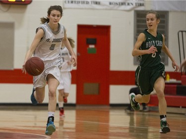 Holy Cross Crusaders Katriana Philipenko looks over as St. Joseph Guardians Emma Johnson moves the ball in the City girls high school basketball city final at Bedford Road Collegiate on Saturday, March 12th, 2016.