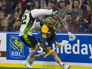 Saskatchewan Rush forward Mark Matthews is not able to stop Georgia Swarm transition Jason Noble in NLL Lacrosse action, March 12, 2016.