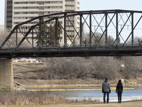 A couple walking on Meewasin Trail in Rotary Park pause to check out the remaining structure of the Traffic Bridge on   March 14, 2016.