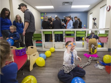 Ten-year-old Daniel Lepage plays with a large pair of sunglasses as Sask Party leader Brad Wall speaks to media at the Ability In Me (AIM) Centre, March 21, 2016.