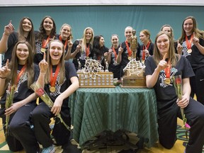 Huskies players gather around their Canada West trophy and the storied Bronze Baby at a Wednesday pep rally.