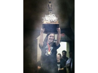 Sure-handed CIS women's University of Saskatchewan Huskies all-star basketball player Dalyce Emmerson almost drops the bronze baby trophy but recovers nicely before gracefully draping the winner's net around her and carrying the championship hardware into a rally in the PAC Gym,  March 23, 2016.