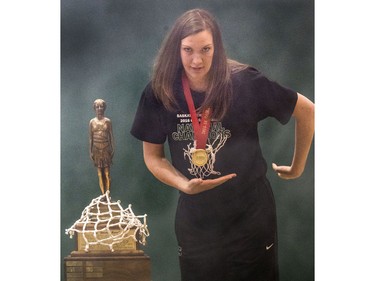 Sure-handed CIS women's University of Saskatchewan Huskies all-star basketball player Dalyce Emmerson almost drops the bronze baby trophy but recovers nicely before gracefully draping the winner's net around her and carrying the championship hardware into a rally in the PAC Gym,  March 23, 2016.