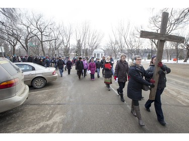 People march and carry a cross down 20th Street West during the Stations of the Cross, a walk which recalls the last hours of the Passion of Jesus, on Friday, March 25th, 2016.