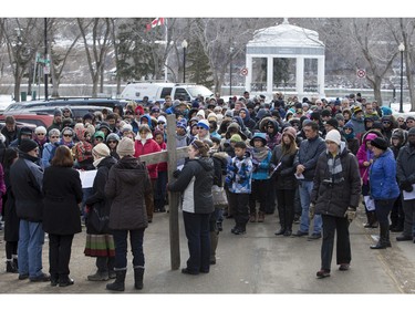 People march and carry a cross down 20th Street West during the Stations of the Cross, a walk which recalls the last hours of the Passion of Jesus, on Friday, March 25th, 2016.