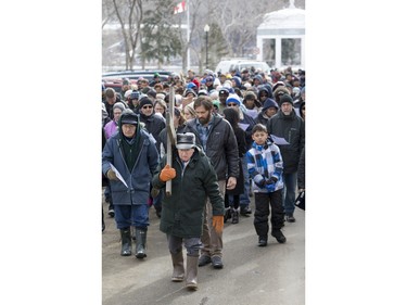 People march and carry a cross down 20th Street West during the Stations of the Cross, a walk which recalls the last hours of the Passion of Jesus, on Friday, March 25th, 2016.