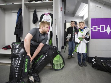 Nine-year-old Cohyn Wells enters the locker room and is greeted by Rush goalie Tyler Carlson, following Wells' signing of a one-day contract with the Saskatchewan Rush, March 26, 2016. Wells is the Saskatchewan representative for the Children's Miracle Network's Champion Program.